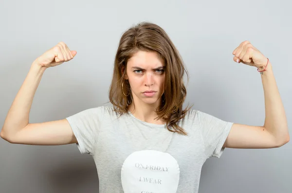 Mujer joven mostrando músculos. — Foto de Stock