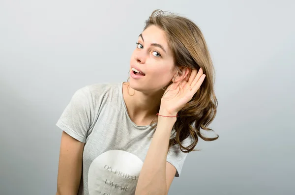 Jovem mulher tentando ouvir algo — Fotografia de Stock