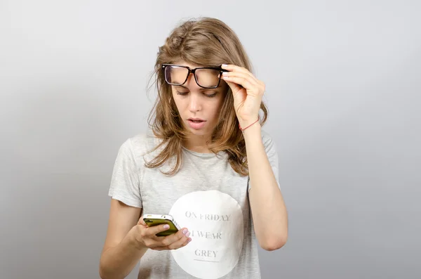 Mujer feliz con gafas usando un teléfono inteligente — Foto de Stock