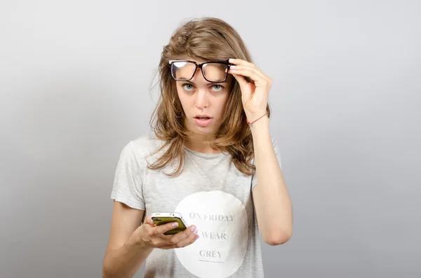 Mulher feliz com óculos usando um telefone inteligente — Fotografia de Stock