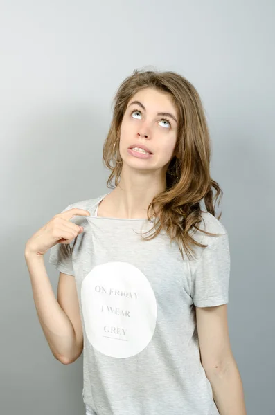 Belleza de pie y tirando de su camisa sobre fondo gris — Foto de Stock