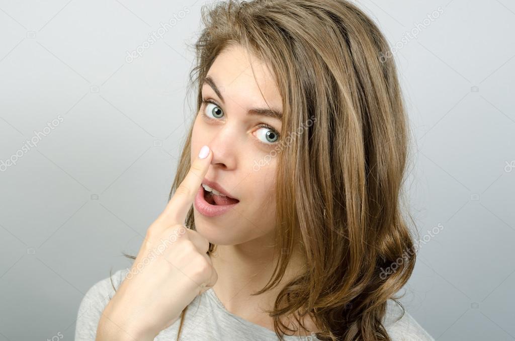 Young happy woman touching her nose Stock Photo by ©Patramansky 95900726