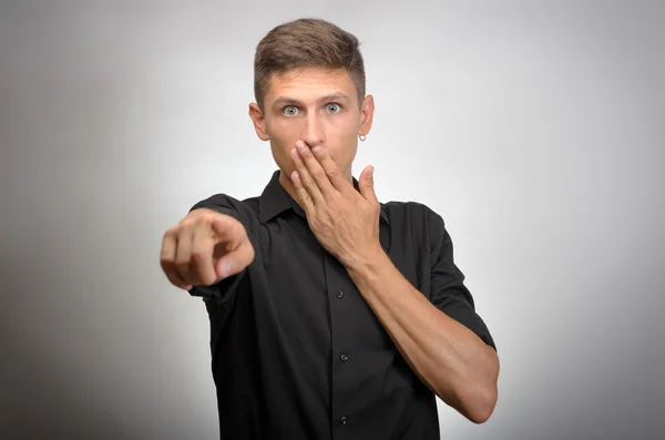 Hombre con expresión sorprendida señalándote sobre un fondo gris —  Fotos de Stock