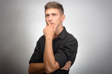 genç yakışıklı adam şüphe gri arka plan üzerinde izole