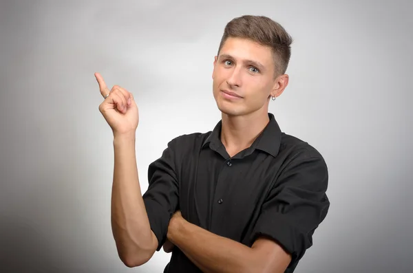 Hombre de negocios apuntando hacia arriba y sonriendo a la cámara — Foto de Stock