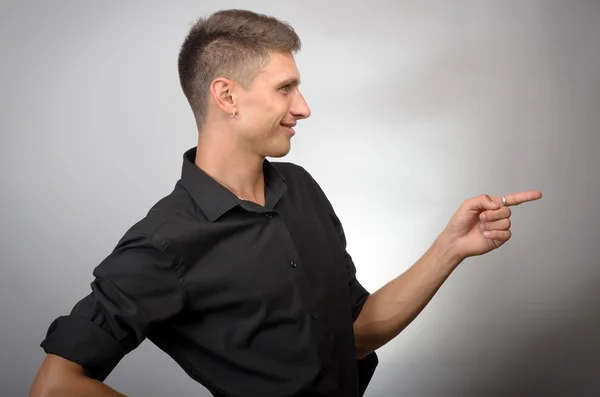 Joven hombre de negocios guapo apuntando a algo usando un dedo. Correcto. — Foto de Stock