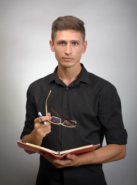 Hombre con gafas en la mano tomando notas en su cuaderno — Foto de Stock