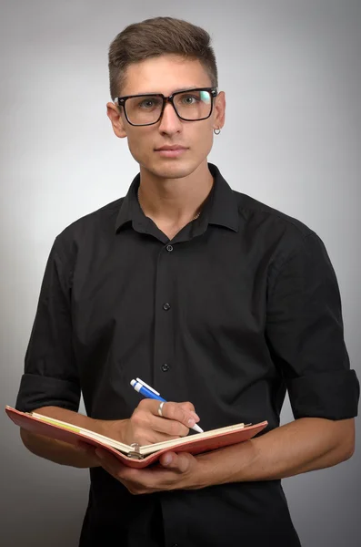 Mann mit Brille macht sich Notizen auf seinem Notizbuch — Stockfoto