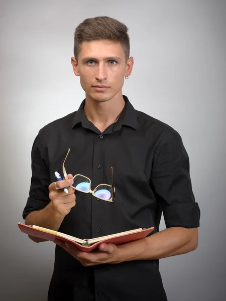 Hombre con gafas en la mano tomando notas en su cuaderno — Foto de Stock