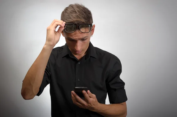 Hombre mirando el teléfono móvil con gafas en la cabeza. Muy perspicaz. Aislado sobre fondo blanco . — Foto de Stock