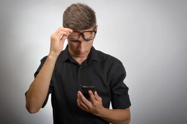 Hombre mirando el teléfono móvil con gafas en la cabeza. Muy perspicaz. Aislado sobre fondo blanco . — Foto de Stock