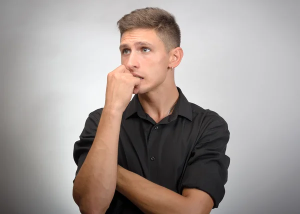 Porträt des jungen denkenden Mannes mit händennahem Gesicht - isoliert auf grau — Stockfoto