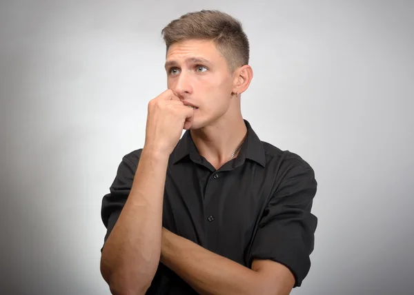 Retrato del joven pensante con la mano cerca de la cara - aislado en gris — Foto de Stock