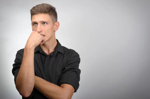 Retrato del joven pensante con la mano cerca de la cara - aislado en gris — Foto de Stock