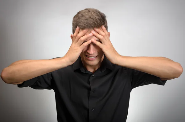 O homem realmente cansado, cobriu o rosto com as mãos. Fundo cinzento — Fotografia de Stock