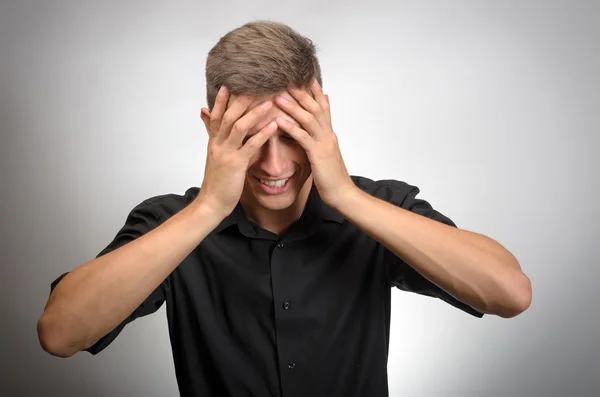 El hombre realmente cansado, se cubrió la cara con las manos. Fondo gris —  Fotos de Stock