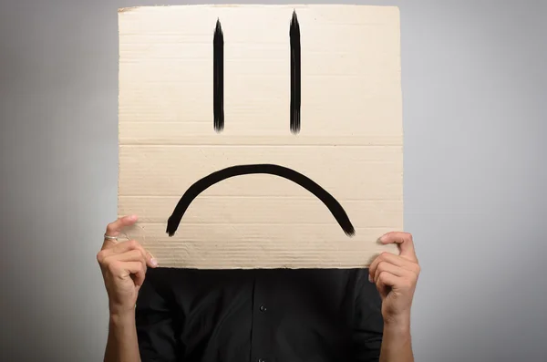 Handsome man with sad smile board. Royalty Free Stock Photos