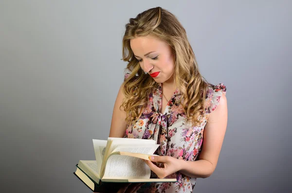 Closeup mulher inteligente leitura livro tendo pensado isolado no fundo da parede cinza. Expressão facial humana — Fotografia de Stock