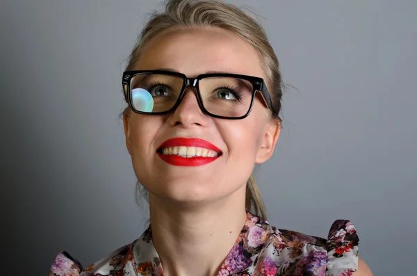 Mulher sorridente de óculos em pé sobre fundo cinza. Vestindo camisa e óculos — Fotografia de Stock