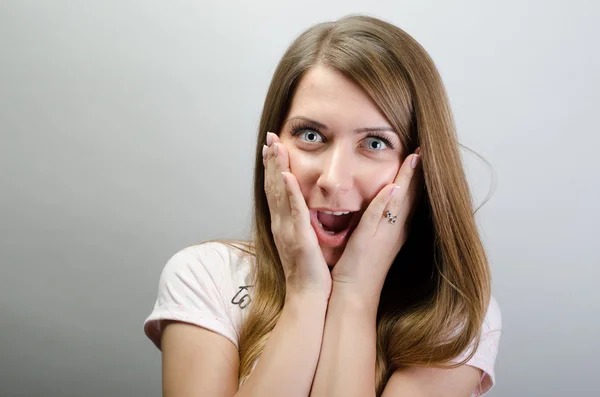 Mujer emocionada sonrisa feliz cubrir su boca a mano palma joven chica atractiva retrato, mirando a la cámara sonriendo aislado sobre fondo gris — Foto de Stock