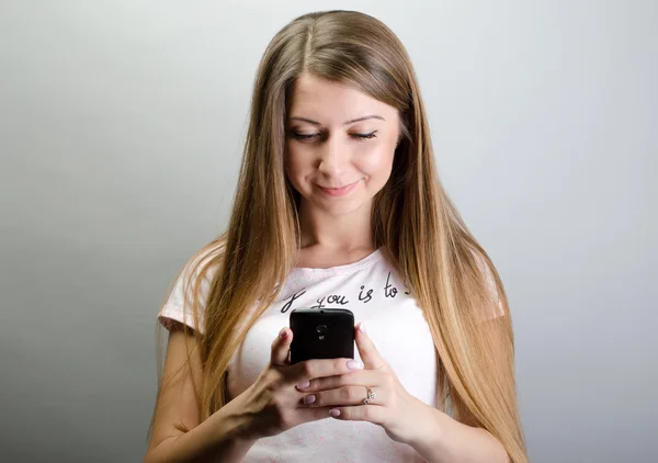 Молода красива жінка з мобільним телефонним розмовником, що вводить смс — стокове фото