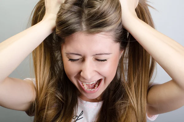 Eine sehr frustrierte und wütende Frau, die an ihren Haaren zieht — Stockfoto