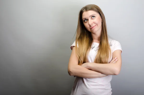 Jeune femme rêveuse debout bras croisés — Photo