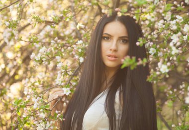 Açık havada gülümseyen genç kadın portresi.