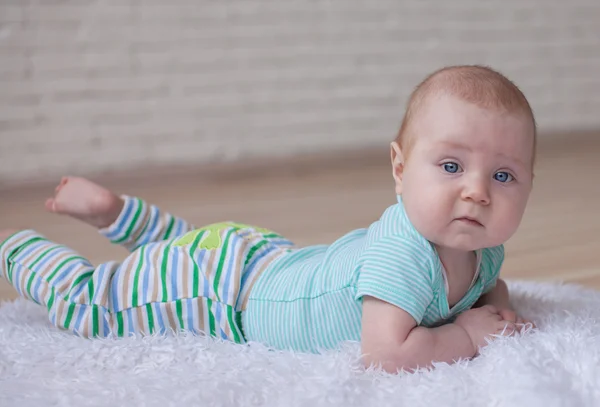 Портрет ползающего ребенка на ковре в его комнате — стоковое фото