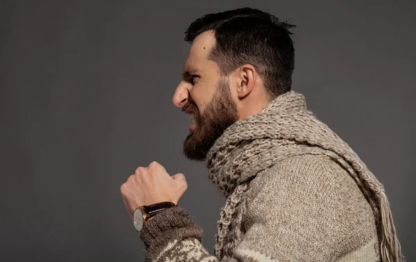 Libérer ses émotions. Vue latérale d'un jeune homme barbu furieux criant debout sur fond gris — Photo