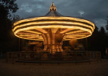 Geceleri aydınlatılmış retro atlıkarınca. Düşük hızlı kepenkle Merry Go Round.