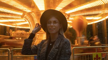 Güzel gülümseyen turist kadın yaz gezisinde lunaparkta eğleniyor..