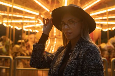 Güzel gülümseyen turist kadın yaz gezisinde lunaparkta eğleniyor..