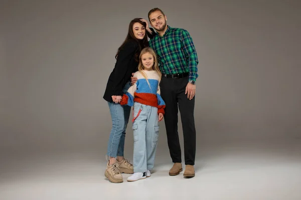 快乐的年轻父母和可爱的小女儿在灰蒙蒙的背景下合影 — 图库照片
