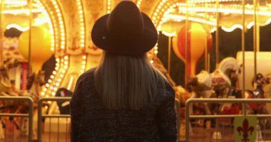 Güzel gülümseyen turist kadın lunaparkta eğleniyor. 
