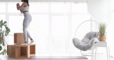 Spor kıyafetli siyahi bir kadın spor yapıyor, yağ yakıyor, dayanıklılık antrenmanı yapıyor, ev hanımı aerobik sporu yapıyor.. 