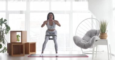 Spor yapan atletik siyah kadın elastik bantla esneme egzersizleri yapıyor, evde antrenman yapıyor. Sağlıklı bir yaşam tarzı. Fitness.