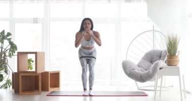 Spor yapan atletik siyah kadın elastik bantla esneme egzersizleri yapıyor, evde antrenman yapıyor. Sağlıklı bir yaşam tarzı. Fitness.