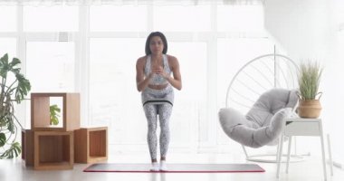 Spor yapan atletik siyah kadın elastik bantla esneme egzersizleri yapıyor, evde antrenman yapıyor. Sağlıklı bir yaşam tarzı. Fitness.