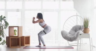 Spor yapan atletik siyah kadın elastik bantla esneme egzersizleri yapıyor, evde antrenman yapıyor. Sağlıklı bir yaşam tarzı. Fitness.