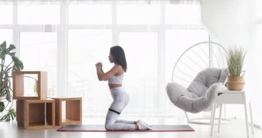 Spor yapan atletik siyah kadın elastik bantla esneme egzersizleri yapıyor, evde antrenman yapıyor. Sağlıklı bir yaşam tarzı. Fitness.