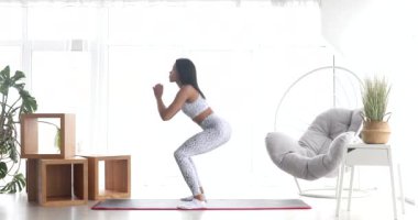 Spor yapan, çömelme egzersizleri yapan, evde antrenman yapan atletik siyah kadın. Sağlıklı bir yaşam tarzı. Fitness.