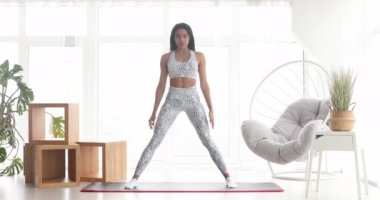 Spor yapan, çömelme egzersizleri yapan, evde antrenman yapan atletik siyah kadın. Sağlıklı bir yaşam tarzı. Fitness.