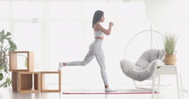 Spor yapan atletik siyah kadın çömelme egzersizleri yapıyor, evde antrenman yapıyor. Sağlıklı bir yaşam tarzı. Fitness.  