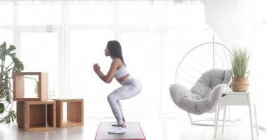 Spor yapan, çömelme egzersizleri yapan, evde antrenman yapan atletik siyah kadın. Sağlıklı bir yaşam tarzı. Fitness.