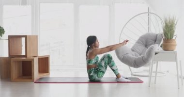 Sportif siyahi kadın evde karın kası egzersizi yapıyor. Spor giyimli atletik kız abdominalleri pompalıyor. Spor ve spor. Antrenman ve sağlık konsepti.