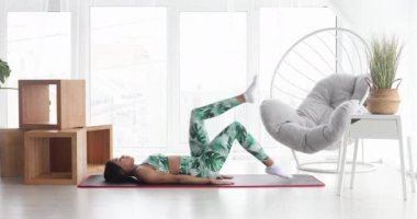 Sportif siyahi kadın evde karın kası egzersizi yapıyor. Spor giyim sektöründe abdominalleri eğiten atletik bir kız. Spor ve spor. Antrenman ve sağlık konsepti.