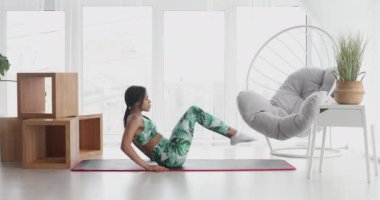 Sportif siyahi kadın evde karın kası egzersizi yapıyor. Spor giyimli atletik kız abdominalleri pompalıyor. Spor ve spor. Antrenman ve sağlık konsepti.