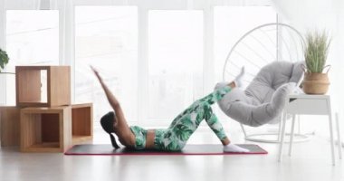 Sportif siyahi kadın evde karın kası egzersizi yapıyor. Spor giyimli atletik kız abdominalleri pompalıyor. Spor ve spor. Antrenman ve sağlık konsepti.