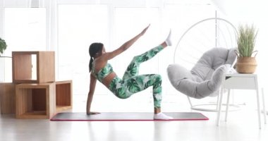 Sportif siyahi kadın evde karın kası egzersizi yapıyor. Spor giyim sektöründe abdominalleri eğiten atletik bir kız. Spor ve spor. Antrenman ve sağlık konsepti.